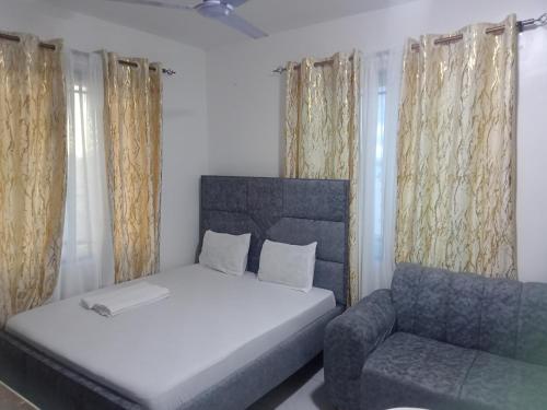 een slaapkamer met een bed en een stoel bij Hmy in Mombasa
