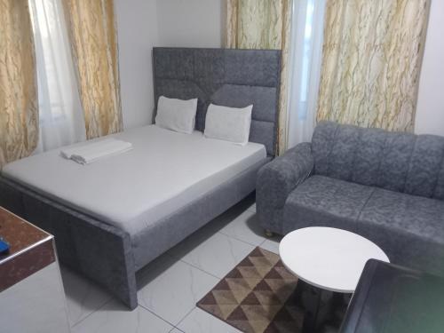 een kleine slaapkamer met een bed en een bank bij Hmy in Mombasa
