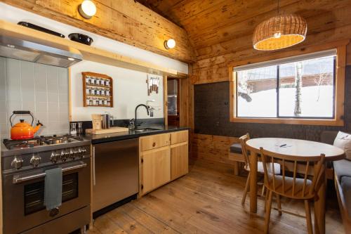 a kitchen and dining room with a table in a cabin at Desolation Hotel Hope Valley in Markleeville