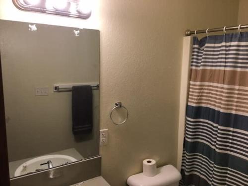 a bathroom with a mirror and a sink and a toilet at Simple 1-bedroom unit upstairs close to Fort Sill! in Lawton