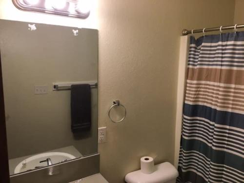 ein Badezimmer mit einem Spiegel, einem Waschbecken und einem WC in der Unterkunft Fort Sill visitor entrance half a mile in Lawton