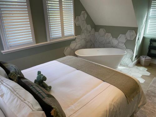 a bedroom with a large bed and a bath tub at Brand New! Bagpipers Luxury Hideaway at Ard Craig House Glencoe in Glencoe