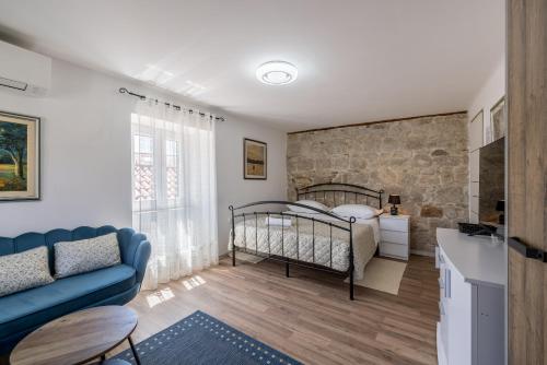 a bedroom with a bed and a stone wall at Holiday Home Riva Promenade in Split
