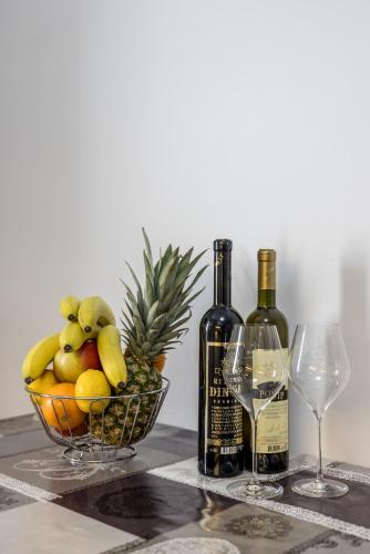 a basket of fruit and two wine glasses on a table at Holiday Home Riva Promenade in Split
