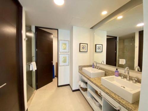 baño con 2 lavabos y espejo grande en Departamento frente al mar, en Cancún