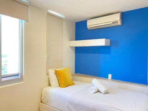 Habitación con cama con almohada amarilla y ventana en Departamento frente al mar, en Cancún