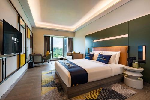 Habitación de hotel con cama grande y TV en MUSTEL Hotel Guangzhou Nansha, en Guangzhou