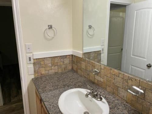uma casa de banho com um lavatório e um espelho em Comfortable downstairs 2 bed next to Fort Sill em Lawton