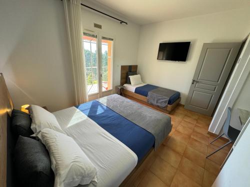 a hotel room with two beds and a television at DOMAINE MAXXIM in Clermont-lʼHérault