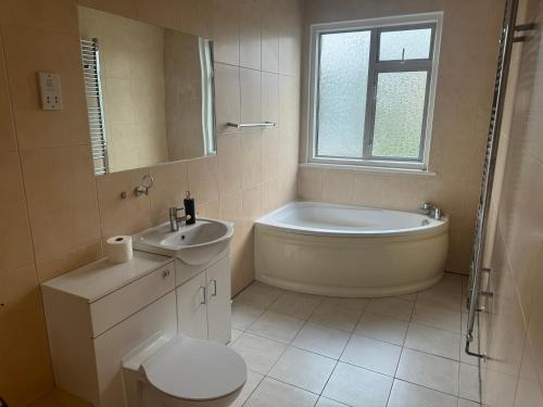 een badkamer met een bad, een toilet en een wastafel bij HANDOVER 3 in Londen