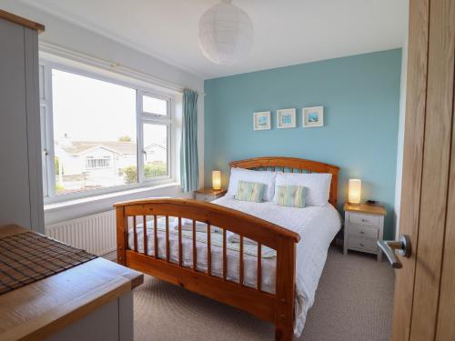 a bedroom with a bed and a large window at Bryn Eithin in Benllech