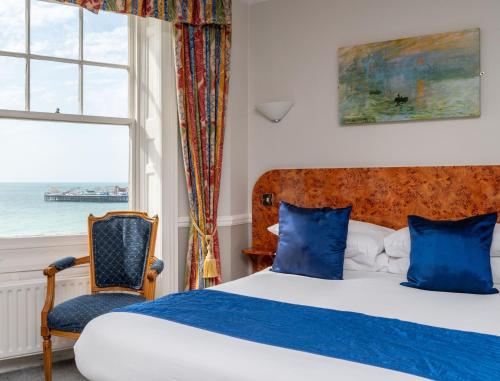 a bedroom with a bed and a chair and a window at The Lanes Hotel in Brighton & Hove