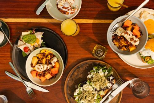 uma mesa de madeira com pratos de comida em Casa Peregrino Holbox em Ilha Holbox