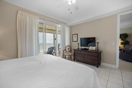 a bedroom with a bed and a dresser and a television at Gulf Front Condo Outdoor Pool & Grill 608 in Orange Beach