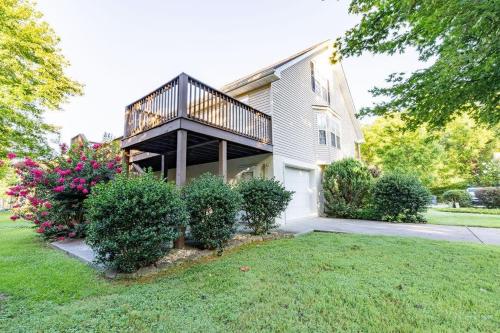 a house with a balcony on top of a yard at Cozy Pigeon Forge home w hot tub near river in Pigeon Forge