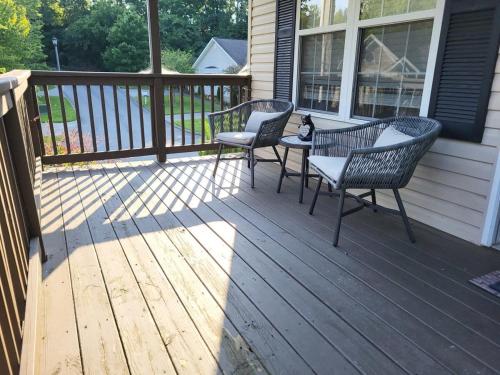 a porch with two chairs and a cat sitting on it at Cozy Pigeon Forge home w hot tub near river in Pigeon Forge