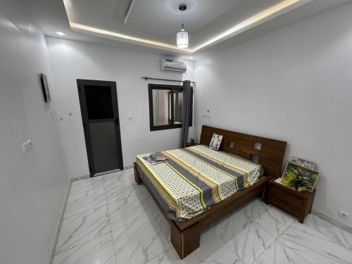 um quarto com uma cama no canto de um quarto em Résidences Salsia - Almadies - Studio RDC em Dakar