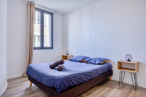 - une chambre avec un lit doté de draps bleus et une fenêtre dans l'établissement Maison T4 Climatisée avec Jacuzzi à Lagord, à Lagord