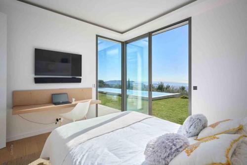 - une chambre avec un lit, une télévision et une fenêtre dans l'établissement Splendid villa with Overflowing swimming pool, à Nice
