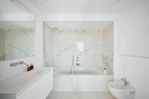 une salle de bain blanche avec une baignoire et un lavabo dans l'établissement Splendid villa with Overflowing swimming pool, à Nice