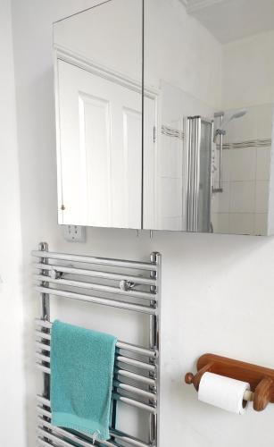 a bathroom with a blue towel on a towel rack at Beech Tree Cottage with free parking in Bury Saint Edmunds