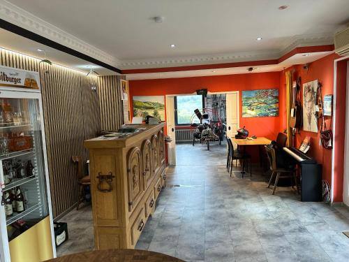 eine Küche mit orangefarbenen Wänden und einem Tisch mit Stühlen in der Unterkunft Green Seeblick Hotel und Apartments am See in Obermaubach