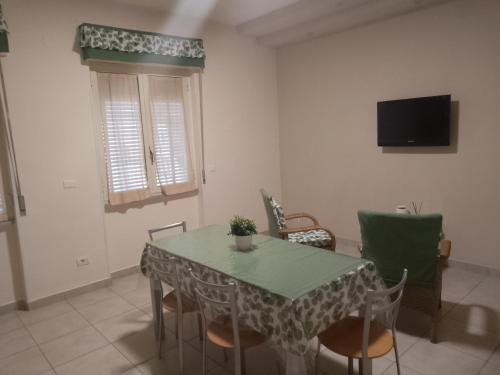 uma sala de jantar com uma mesa e cadeiras e uma televisão em Orchidea1 em Marcianise