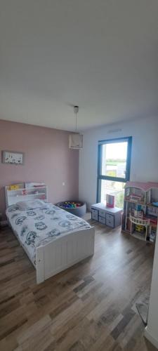 une chambre avec un grand lit et une fenêtre dans l'établissement Maison familiale 120 m2 à 15 minutes de la mer, à Lanmeur