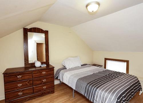 1 dormitorio con cama, tocador y espejo en Story book cottage, en Knoxville