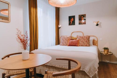 Apparts' Rennes BnB Solferino -Centre Gare في رين: غرفة نوم صغيرة مع سرير وطاولة