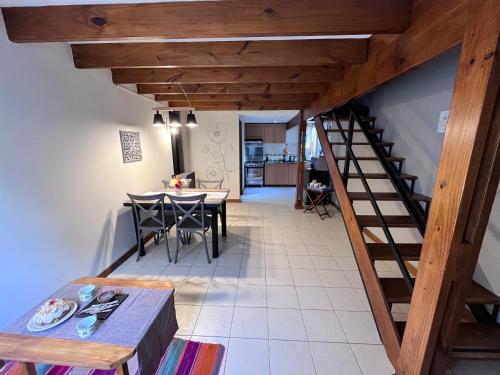 uma cozinha e sala de jantar com uma escada e uma mesa em Narcisos y Amapolas en Ushuaia em Ushuaia