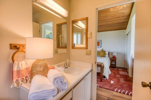 a bathroom with a sink and a mirror at #StayinMyDistrict Cape Arago Ocean Studio Suite in Coos Bay
