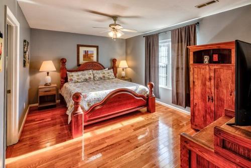 um quarto com uma cama vermelha e uma televisão em Entire house close to everything in Sevier County em Pigeon Forge