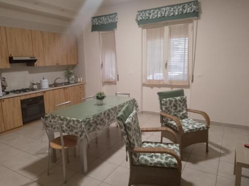 uma cozinha com mesa e cadeiras num quarto em Orchidea1 em Marcianise