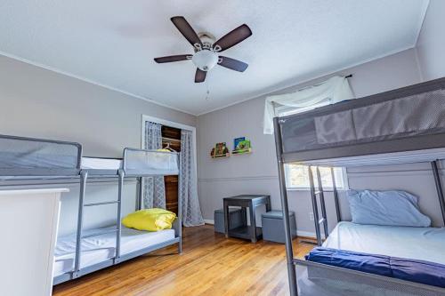 a room with three bunk beds and a ceiling fan at Single Family Home in Rossville GA! in Rossville
