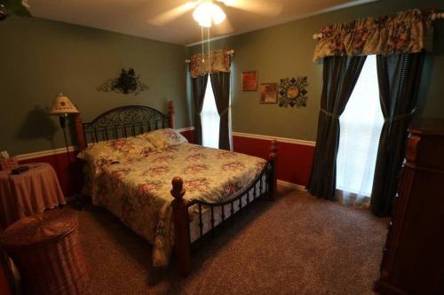 1 dormitorio con 1 cama y 2 ventanas en 3 bed 2 and a half bath sleeps 10 max with fenced in backyard en Hendersonville