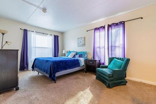 a bedroom with a blue bed and a green chair at Apartment living 2 bed and bath in Chattanooga