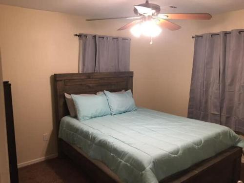 a bedroom with a bed with a ceiling fan at Be comfortable in a house close to base in Lawton