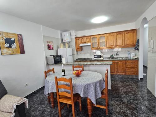 Apartamento Mendoza-San Isidro في سان إيسيذرو: مطبخ مع طاولة وكراسي ومطبخ مع أجهزة بيضاء