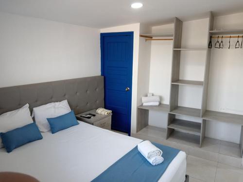 a bedroom with a bed and a blue door and shelves at Cozzy studio inside walled city & historic center in Cartagena de Indias