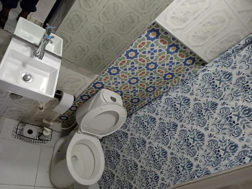 a bathroom with a white toilet and a sink at Cozzy studio inside walled city & historic center in Cartagena de Indias