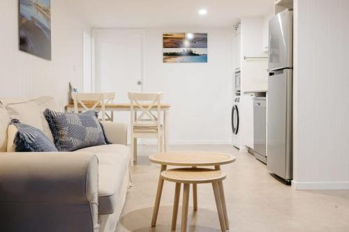 a living room with a couch and a table at Moffat Beach Coastal Contemporary Unit B in Caloundra