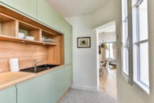 une cuisine avec un évier et un couloir dans l'établissement Maison au pied de la plage, à Les Sables-dʼOlonne