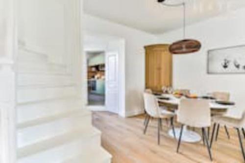 une cuisine et une salle à manger avec une table et des chaises dans l'établissement Maison au pied de la plage, à Les Sables-dʼOlonne