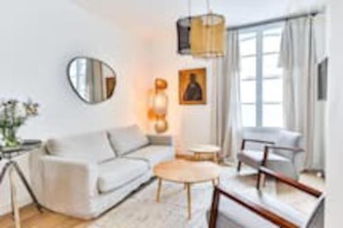 un salon avec un canapé blanc et une table dans l'établissement Maison au pied de la plage, à Les Sables-dʼOlonne