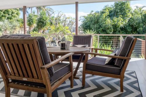 two chairs and a wooden table on a balcony at Moffat Beach, Large families & friends unite here! in Caloundra