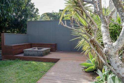 a garden with a wooden deck and a tree at Moffat Beach, Large families & friends unite here! in Caloundra