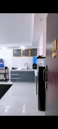 een keuken met een zwarte koelkast en een wastafel bij Posh Peak Homes Kilimani 2 in Nairobi