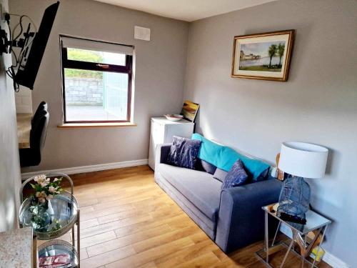 a living room with a blue couch and a window at Creevelea Manor in Galway