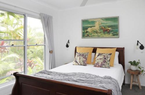 um quarto com uma cama e uma grande janela em Buderim Rainforest Retreat - 10 mins to Mooloolaba em Buderim